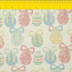 Op de afbeelding: Een herhalend patroon van pastelkleurige paasei-ontwerpen met strikken en bloemmotieven. De eieren zijn in roze, blauw, groen en geel op een crèmekleurige achtergrond. Geschikt voor stof of behang.