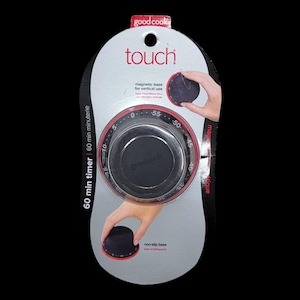 May include: A black and silver kitchen timer with a red dial and the text "good cook touch". The timer has a magnetic base for vertical use and a non-slip base. The timer is packaged in a white and black blister pack.
