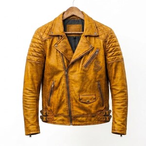 May include: A mustard yellow leather motorcycle jacket featuring an asymmetrical front zip, quilted shoulder panels, multiple zipped pockets, a small snap-button pocket, and adjustable side buckles at the hem with a dark grey interior lining.