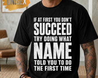 May include: A black short-sleeved t-shirt featuring white distressed-style text that reads: IF AT FIRST YOU DON'T SUCCEED TRY DOING WHAT NAME TOLD YOU TO DO THE FIRST TIME. The shirt has a crew neckline and a standard fit for a casual appearance.