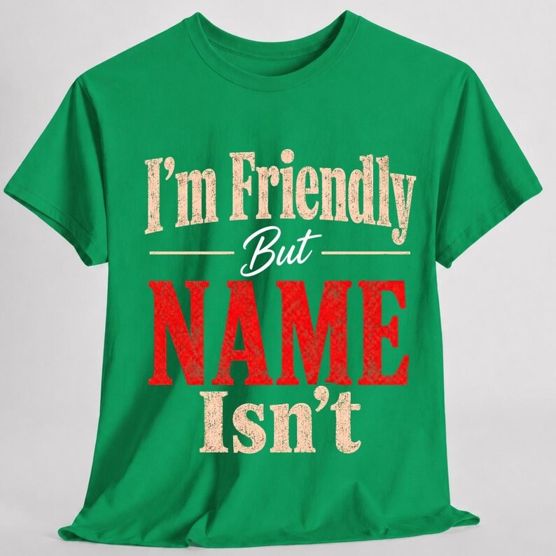 May include: A bright green short-sleeved t-shirt featuring the text "I'm Friendly But NAME Isn't" printed on the front. The words "I'm Friendly But" and "Isn't" are in a distressed beige font, while the word "NAME" is in a large, bold red font.