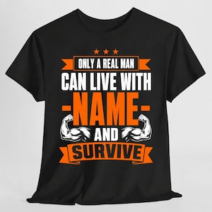 Może przedstawiać: Czarny t-shirt z krótkim rękawem z białym i pomarańczowym napisem ONLY A REAL MAN CAN LIVE WITH NAME AND SURVIVE. Wzór zawiera trzy pomarańczowe gwiazdki u góry oraz dwie ilustracje umięśnionych ramion po obu stronach słowa NAME.