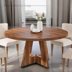 May include: A round wooden dining table with a patterned surface, supported by a geometric base. The table is surrounded by four cream-colored chairs. A white vase with pink flowers and two smaller white decorative vases are on the table. The text "Elegant Home Livingg" is in the top left corner.