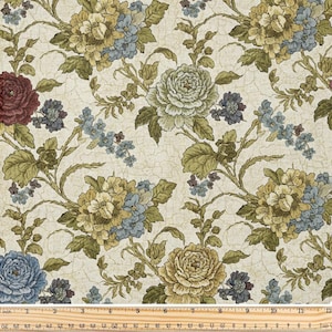 May include: Fabric featuring a floral design with a cream backdrop and a repeating pattern of large flowers in blue, green, yellow, and burgundy. A wooden ruler with cm measurements is at the bottom.