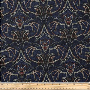May include: Dark blue fabric with a repeating pattern of stylized bats in shades of red, cream, and brown. The bats are arranged in a symmetrical design, creating a gothic or Halloween theme. The fabric has a textured appearance.