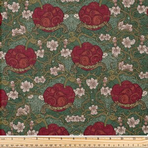 Op de afbeelding: Stof met een herhalend patroon van grote, gestileerde rode bloemvormen met gouden accenten op een groene achtergrond. Kleine witte bloemen en bruine wijnstokken vullen de ruimtes. De liniaal meet tot 30 cm.