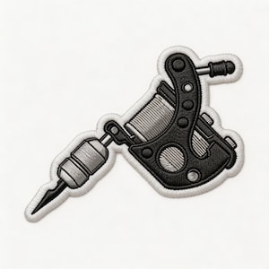 May include: Embroidered patch featuring a black and gray tattoo machine design. The patch has a detailed outline and a white border. The tattoo machine is depicted in a realistic style, with intricate details.