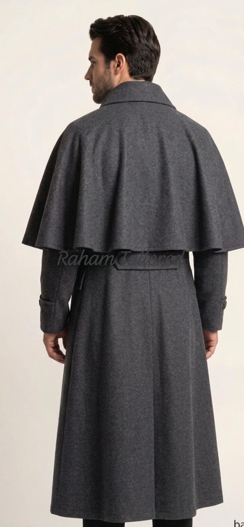 May include: A charcoal gray wool coat with a cape-like shoulder design. The long coat features a belt at the waist and buttoned cuffs. The text "Raham Tailors" is visible on the back of the coat.