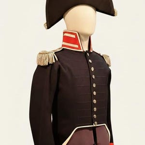 May include: A dark navy blue military uniform with gold epaulettes, a red and white collar, and red cuffs. The uniform includes a black bicorne hat with a white plume. The jacket has gold buttons and a white trim.