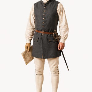 May include: A historical costume featuring a dark gray vest with gold buttons, a brown leather belt, and a sword. The outfit includes a cream-colored shirt, breeches, and black leather shoes. A map is held in one hand.