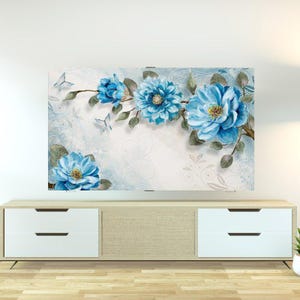 May include: A floral wall art piece featuring large, light blue flowers with yellow centres and green leaves. The artwork includes butterflies and is set against a light blue and white background with decorative swirls.