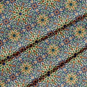 May include: Close-up of a fabric with a repeating geometric pattern. The design features a complex arrangement of shapes in shades of blue, green, orange, and brown against a cream background. The fabric is folded, creating shadows and depth.