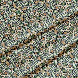 Può includere: Primo piano di un tessuto con un motivo geometrico ripetuto. Il design presenta intricati motivi a forma di stella in tonalità di blu, verde e oro su uno sfondo color crema. Il tessuto ha un aspetto strutturato, con pieghe che aggiungono profondità al design.