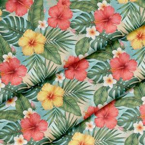 May include: Tropical floral patterned fabric. The design includes red and yellow hibiscus flowers, white plumeria, and green palm leaves on a light blue and beige background. The fabric is folded, displaying the repeating pattern.