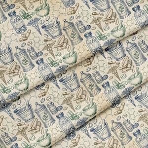 Op de afbeelding: Stof met een herhalend patroon van vintage apotheek illustraties. Het ontwerp bevat apothekerspotten, vijzels en stamper, pillen en het caduceus symbool in blauw, groen en bruin op een crèmekleurige achtergrond.