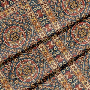 Puede incluir: Primer plano de una tela estampada con un diseño de alfombra tradicional. La tela presenta un patrón repetitivo de formas geométricas en tonos azul marino, rojo, dorado y beige. El diseño incluye medallones y bordes.