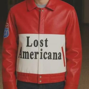 May include: Red and white leather jacket with the text "Lost Americana" across the chest. The jacket has a classic collar, button closure, and a patch on the left sleeve. The jacket is a bold statement piece.
