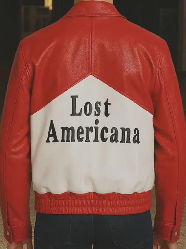 May include: Red and white leather jacket with the text "Lost Americana" on the back. The jacket has a classic bomber style with a ribbed hem and cuffs. The design features a bold color block pattern.