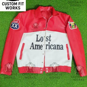 Puede incluir: Chaqueta de cuero roja, blanca y negra con el texto "Lost Americana". La chaqueta tiene cierre de botones, cuello y parches en las mangas. El logotipo de Custom Fit Works es visible.
