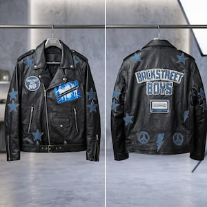 Op de afbeelding: Zwarte leren jas met blauwe sterpatches en de tekst "Backstreet Boys" op de rug. Het heeft een klassiek biker-ontwerp met een reverskraag, ritssluiting en zakken. De jas heeft een riem in de taille.
