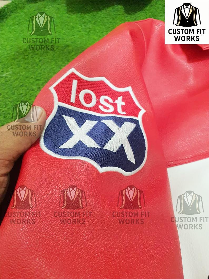 May include: Close-up of a red leather jacket with a white and blue embroidered patch that reads "lost" above the letters "XX". The jacket has the text "CUSTOM FIT WORKS" printed on it.