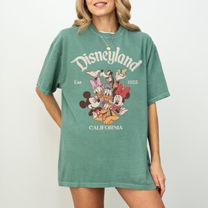 Op de afbeelding: Een witte keramische mok met een zwart handvat en de tekst "But First, Coffee" in een zwarte, handgeschreven lettertype. De mok staat op een wit oppervlak.