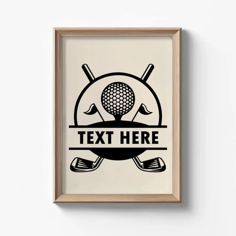 May include: Framed print featuring a black and white golf-themed design. The artwork includes a golf ball on a tee, crossed golf clubs, and the text "TEXT HERE" in a rectangular banner. Two small flags flank the golf ball.