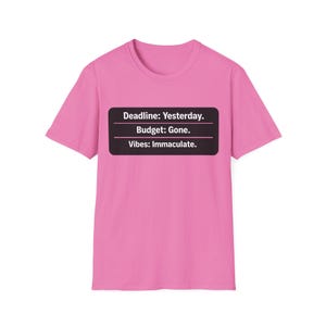 Puede incluir: Camiseta rosa con un diseño rectangular negro. El diseño contiene el texto "Deadline: Yesterday. Budget: Gone. Vibes: Immaculate." en blanco. La camiseta es de cuello redondo.