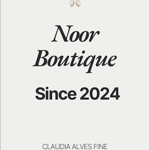 May include: A cream-coloured graphic featuring the words "Noor Boutique Since 2024" in black, with a butterfly-like design above. The text "CLAUDIA ALVES FINE ARTIST" is at the bottom of the image.