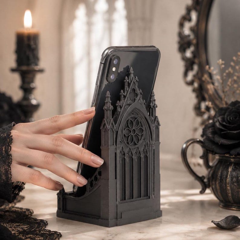 Black Gothic Cathedral phone stand displayed on a modern desk holding a smartphone.
Side view of Gothic Cathedral phone holder showing detailed medieval window design.
Front view of cathedral-inspired smartphone stand with gothic architectural details.