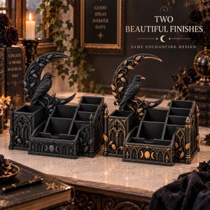 May include: Two desk organisers featuring a crescent moon and raven motif. One organiser is solid black, while the other has gold-toned accents on the leaves and moon. Both have multiple compartments and gothic-style architectural detailing.