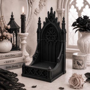 Black Gothic Cathedral phone stand displayed on a modern desk holding a smartphone.
Side view of Gothic Cathedral phone holder showing detailed medieval window design.
Front view of cathedral-inspired smartphone stand with gothic architectural details.