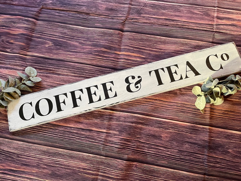May include: White wooden sign with black lettering that reads "COFFEE & TEA CO."