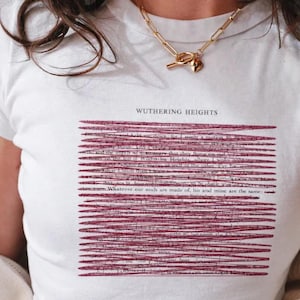 Può includere: T-shirt bianca con la scritta "WUTHERING HEIGHTS" sopra un disegno di linee orizzontali rosse. La maglietta ha uno scollo tondo e viene indossata con una collana a catena dorata.