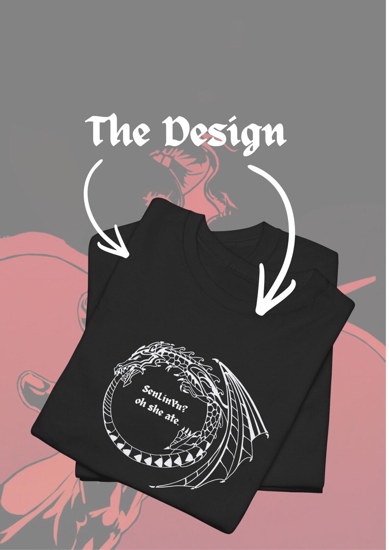 Op de afbeelding: Zwart T-shirt met een wit drakenontwerp en de tekst "SenLinVu? oh she ate." Het shirt is opgevouwen, met de tekst "The Design" erboven. Het ontwerp is een fantasie-thema grafisch.