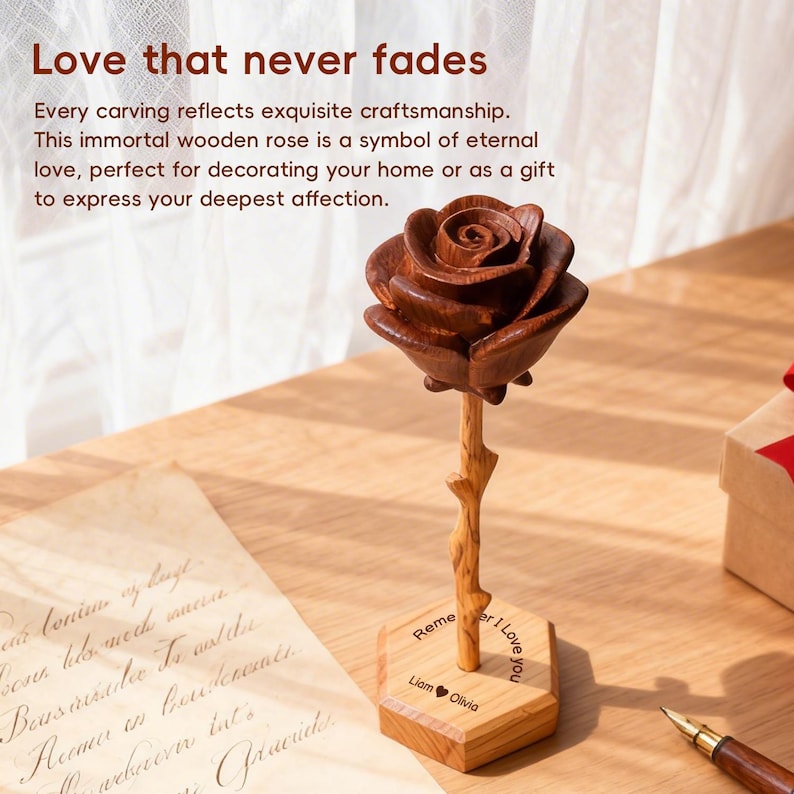 K&ouml;nnte beinhalten: Eine geschnitzte Holzrosenskulptur mit einem dunkelbraunen Bl&uuml;tenkopf und einem hellbraunen Stiel. Die Rose ist auf einem sechseckigen Holzsockel montiert, der den eingravierten Text "Remember I Love you" sowie die Namen "Liam" und "Olivia" mit einem Herz zeigt.