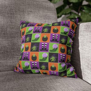 May include: A square throw pillow featuring a repeating grid pattern of Halloween-themed illustrations. The design includes green-skinned witches, black cauldrons with bubbling green liquid, purple crystal balls held by green hands, and black and white striped stockings with black pointed shoes, set against alternating orange, green, and purple squares.