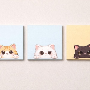 Könnte beinhalten: Drei quadratische Haftnotizen mit Illustrationen von Cartoon-Katzen. Die Katzen sind orange getigert, weiß und schwarz, jede schaut über den Rand der Notiz. Die Hintergründe der Notizen sind hellblau und gelb.