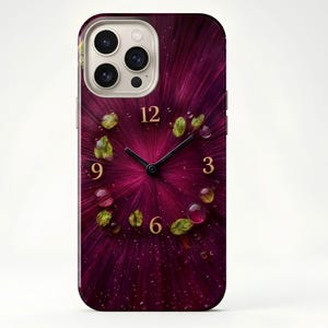 Puede incluir: Funda de teléfono con un diseño abstracto de reloj. El fondo es magenta intenso con líneas radiales. Las manecillas señalan las 10:15. Los números son dorados, con hojas verdes y gotas de agua.
