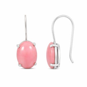 May include: A pair of silver-toned drop earrings featuring oval, light pink gemstones. The gemstones are set in a silver frame with four prongs. The earrings have a simple, curved hook design.