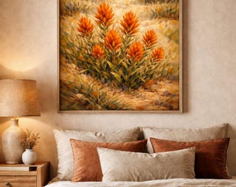 Puede incluir: Una pintura de paisaje enmarcada representa un campo de flores silvestres naranjas con un fondo montañoso. La obra de arte cuelga sobre una cama con almohadas de color canela y óxido y una manta tejida. Se ve una mesita de noche de madera con una lámpara.