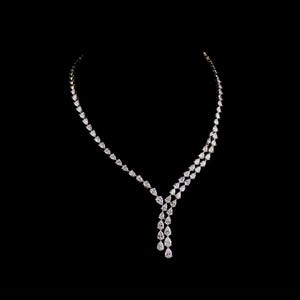 Könnte beinhalten: Elegante Halskette mit einer Kaskade aus tropfenförmigen, klaren Edelsteinen. Die Halskette hat ein zartes, symmetrisches Design mit einem zentralen Tropfen, perfekt für formelle Anlässe. Die Edelsteine sind in einem silberfarbenen Metall gefasst.