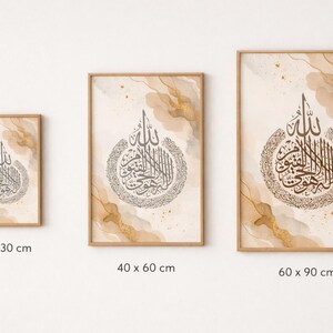 May include: Three framed art prints with Arabic calligraphy in neutral tones. The prints are sized at 20 x 30 cm, 40 x 60 cm, and 60 x 90 cm. Each print has a wooden frame and a watercolour background with gold accents.