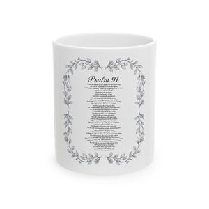 May include: White ceramic mug with the text "Psalm 91" in black, framed by a floral wreath. The mug's surface is printed with the full text of Psalm 91 in black, creating a visually appealing and inspirational design.