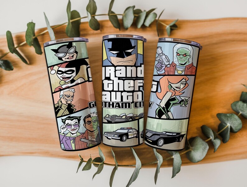 May include: Three cylindrical metal tumblers featuring a comic book style graphic print. The designs include illustrations of various characters, a police car, and a black vehicle, with the text Grand Theft Auto Gotham City displayed prominently.
