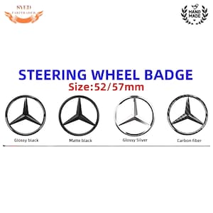 May include: Four steering wheel badges with a star logo. The options include glossy black, matte black, glossy silver, and carbon fiber. The text "STEERING WHEEL BADGE" and "Size: 52/57mm" are displayed above the badges.