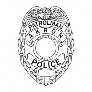 May include: Black and white police badge with an eagle at the top. The badge reads "PATROLMAN AKRON STATE OF OHIO POLICE" in a stylized font, surrounded by a laurel wreath design.