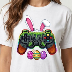 Könnte beinhalten: Weißes T-Shirt mit einem pixeligen Videospiel-Controller-Design, Hasenohren und drei Ostereiern. Der Controller ist grün und braun mit bunten Knöpfen. Der Text unten lautet "HIGH QUALITY . 300DPI PNG . FILE".