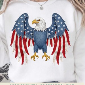 May include: White sweatshirt with a patriotic eagle design. The eagle has blue denim wings with white stars and red and white striped feathers. The eagle's body is blue, with a white head and yellow beak and talons. The text "HIGH QUALITY . 300DPI PNG . FILE" is at the bottom.