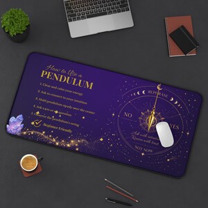 May include: A purple and gold pendulum mousepad with instructions, a pendulum graphic, and the text "How to Use a Pendulum." Includes a white mouse, a laptop, and a cup of coffee.
